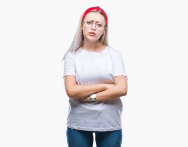 İzole arka plan şüpheci ve çapraz kolları olan yüzündeki gergin, onaylamayan ifade gözlüklü sarışın genç kadın. Negatif kişi.