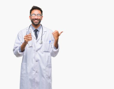 Yetişkin İspanyol doktor adam işaret ve başparmak kadar mutlu yüz gülümseyen tarafı ile gösteren izole arka plan üzerinde bardak su içme