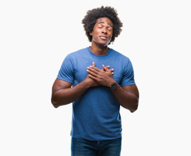 Afro Amerikalı adam ile gülümseyen izole arka plan üzerinde kapalı gözler ve yüzünde minnettar jest ile göğüs üzerinde eller. Sağlık kavramı.