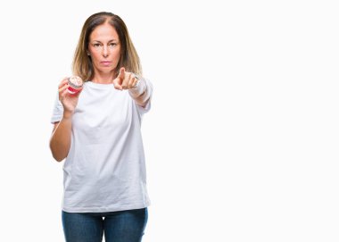 Orta yaş İspanyol kadın üzerinde kek yeme kamera ve size parmak ile işaret arka plan izole, el işareti, pozitif ve kendinden emin bir jest ön