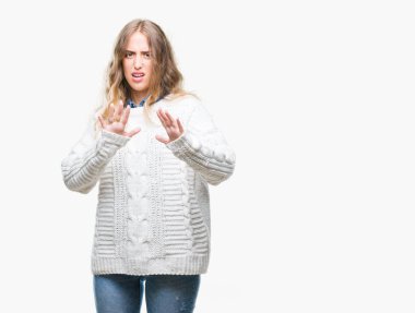 Şokta bağırarak korkuyor ve dehşet korku ifade dur hareketi el ile ile izole arka plan üzerinde kış kazak giyen güzel sarışın genç kadın. Panik kavramı.