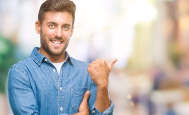 Yakışıklı delikanlı arıyor ve başparmak yanında yukarıyı mutlu yüz ile gülümseyen izole arka plan üzerinde.