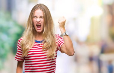 İzole arka plan öfkeli ve sinirli sinirli ve öfke ile bağırarak süre öfkeli yumruk yükselterek genç güzel sarışın kadın. Öfke ve agresif kavramı.