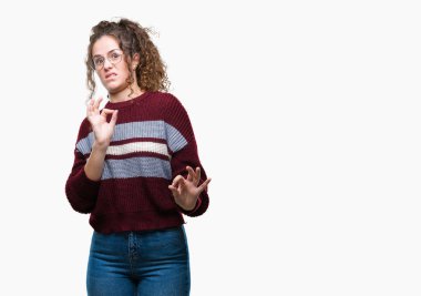 Güzel esmer kıvırcık saçlı Genç kız izole arka plan üzerinde gözlük tiksinti ifadesi, memnun ve korkulu tiksinti yüz yapıyorsun çünkü nefret tepki. Elleriyle kaldırdı. Sinir bozucu kavramı.