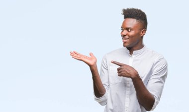 Genç Afro-Amerikan adam üzerinden hayran ve el ile sunulması ve parmak ile işaret ederken kameraya gülümseyen izole arka plan.