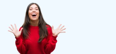 Çılgın ve silah ile başarı için hayran kutlama kırmızı kazak giyen genç güzel İspanyol kaldırdı ve açık gözleri çığlık heyecanlı. Kazanan kavramı