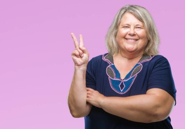 Kıdemli artı boyutu mutlu yüz zafer yaparken kameraya göz kırpıyor ile gülümseyen arka plan üzerinde beyaz kadın izole işareti. İki numaralı.