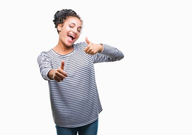 El ile pozitif jest yapıyor onaylama izole arka plan üzerinde kazak giyen genç örgülü saç Afro-Amerikan Kız başparmak gülümseyen ve başarı için mutlu. Kamera, kazanan jest arıyorsunuz.