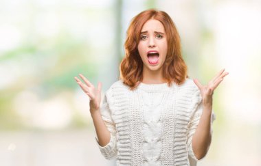 Genç güzel kadın çılgın kutlama kış kazak giyen ve silah ile başarı için heyecanlı çığlık kaldırdı ve açık gözleri hayret izole arka plan yüzünden. Kazanan kavramı