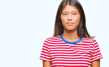 Genç Asyalı kadın yüzünde ciddi bir ifade ile izole arka plan üzerinde. Basit ve doğal kameraya bakıyor.