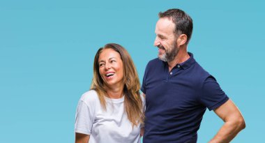 Orta yaş İspanyol rahat çift uzakta yanında seyir izole arka plan üzerinde yüzünde, doğal ifade gülümse. Kendine güvenen gülüyor.