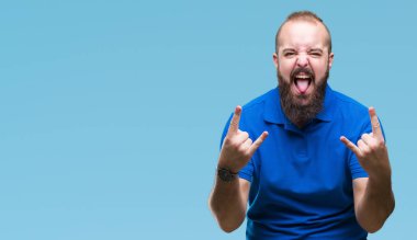 Genç beyaz hipster adam deli ifade rock simge elle yapıyor ile bağırarak izole arka plan üzerinde mavi tişört giyiyor. Müzik yıldızı. Ağır kavramı.
