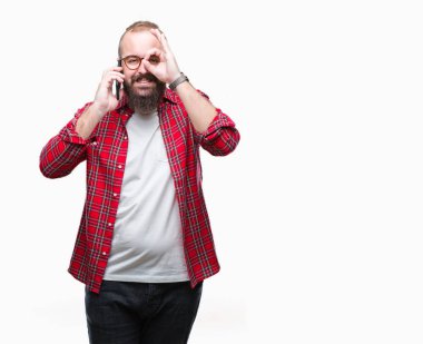 Smartphone ile mutlu yüz el parmaklarının arasından seyir göz üzerinde ok işaretiyle yapıyor gülümseyen izole arka plan üzerinde konuşan genç beyaz hipster adam