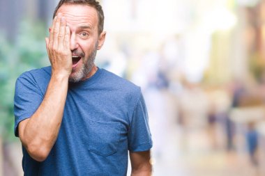 Orta yaş ağarmış komuta sizde bir göz ile yüz ve sürpriz duygu kendinden emin gülümseme ile el kapsayan izole arka plan üzerinde.