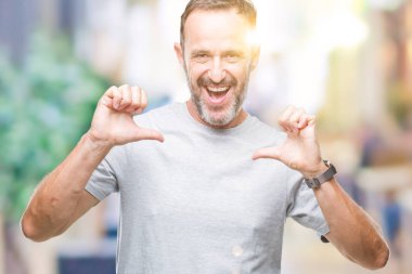 Orta yaş üst düzey ağarmış adam yüzünde gülümseme ile kendinden emin görünüyorsun, kendini gururlu ve mutlu parmakları ile işaret izole arka plan üzerinde.