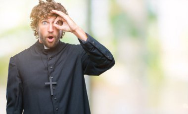 Sürpriz yüz, göz parmaklarının arasından seyir ile ok jest yapıyor izole arka plan yakışıklı İspanyol Katolik rahip adam şok. İmansız ifade.