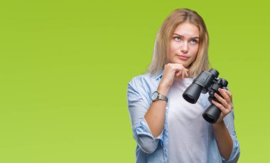 İzole arka plan ciddi bir yüz düşünme hakkında soru, çok karışık bir fikir üzerinde dürbün tutan genç beyaz kadın