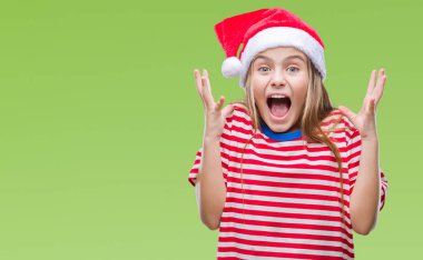 Üzerinde Noel şapka giyen genç güzel kız deli kutluyor arka plan izole ve başarı için kaldırdı kollarını açarak hayrete ve heyecanlı çığlık gözleri açık. Kazanan kavramı