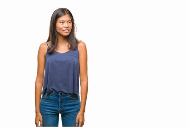 Genç Asyalı kadın uzak tarafına yüzünde, doğal ifade gülümseme ile seyir izole arka plan üzerinde. Kendine güvenen gülüyor.