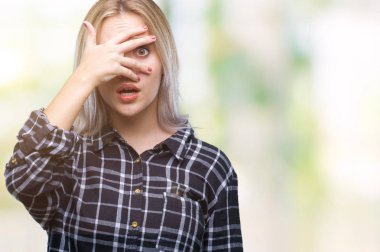 Mahcup ifadeyle parmaklarımın arasından seyir izole arka yüz ve gözler el ile kapsayan şok bakmak genç sarışın kadın.