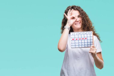 Adet takvim ile mutlu yüz el parmaklarının arasından seyir göz üzerinde ok işaretiyle yapıyor gülümseyen izole arka plan üzerinde tutan genç esmer kız