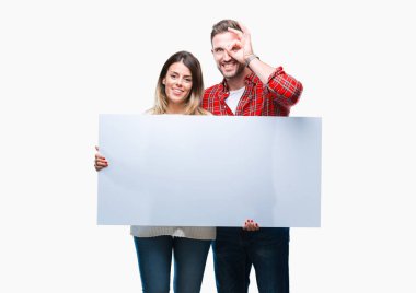 Genç çift birlikte holding boş afiş ile mutlu yüz el parmaklarının arasından seyir göz üzerinde ok işaretiyle yapıyor gülümseyen izole arka plan üzerinde