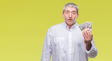 Yakışıklı komuta sizde para demet izole arka plan üzerinde bir sürpriz yüz, korkuyor ve heyecanlı korku ifadesi ile şok korkmuş holding