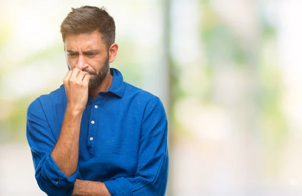 成年西班牙裔男子在孤立的背景下 看着压力和紧张的嘴咬指甲的手 焦虑问题 — 图库照片