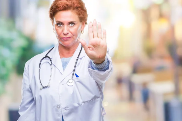先輩の白人医師女性以上医療制服を着て分離バック グラウンド停止手の手のひらで歌う 顔に否定的な深刻なジェスチャーで警告式 — ストック写真