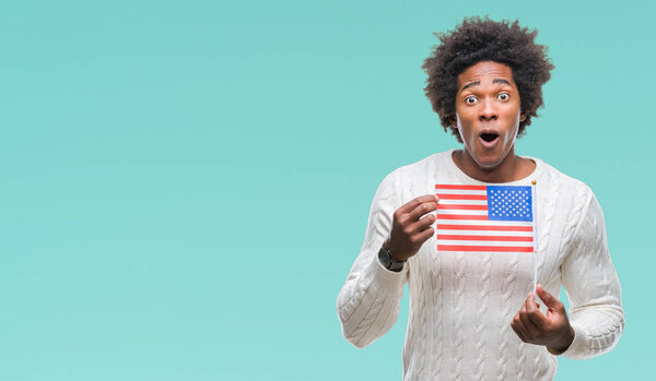 Afro american man flag of United States of America over isolated background scared in shock with a surprise face, afraid and excited with fear expression