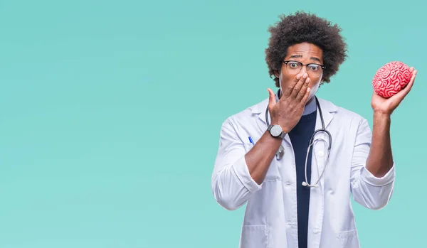 Afro american neurologist doctor or psychology man over isolated background cover mouth with hand shocked with shame for mistake, expression of fear, scared in silence, secret concept