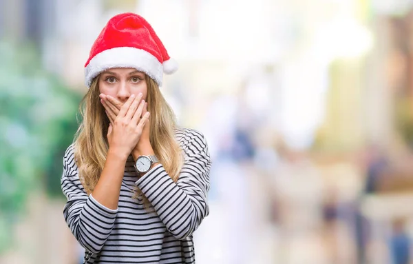 年轻美丽的金发女子戴着圣诞节帽子在孤立的背景震惊地覆盖口与手错误 秘密概念 — 图库照片