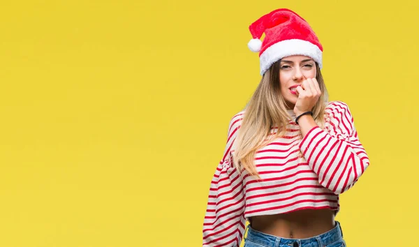年轻美丽的妇女戴着圣诞节帽子在孤立的背景下看紧张和紧张与手在嘴咬指甲 焦虑问题 — 图库照片