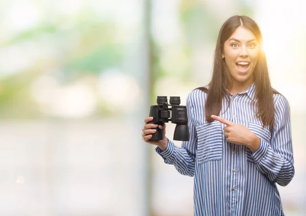 Jovem Hispânica Segurando Binóculos Muito Feliz Apontando Com Mão Dedo — Fotografia de Stock