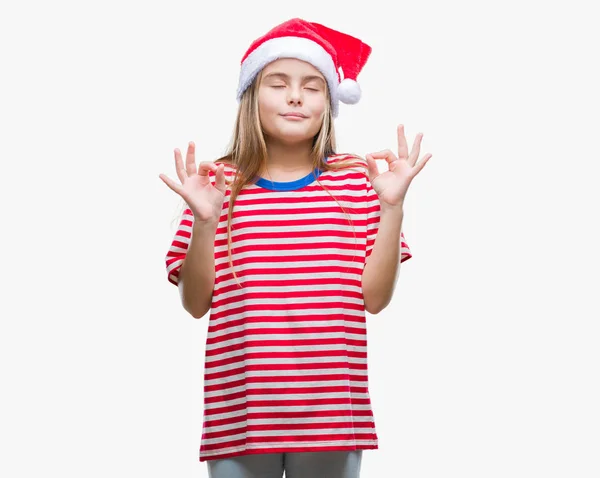 孤立した背景の上身に着けているクリスマスの帽子を美しい少女リラックスして瞑想の指ジェスチャーをやって閉じた目を浮かべてします ヨガの概念 — ストック写真