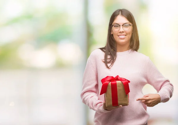 Young Hispanic Woman Holding Gift Very Happy Pointing Hand Finger — Stock Photo, Image