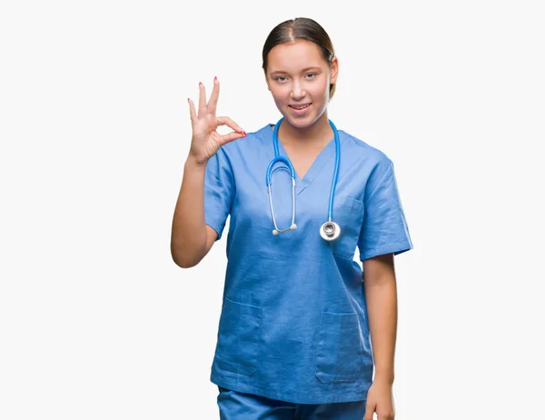 孤立した背景を浮かべて手と指で サインをしている肯定的な上医療制服を着て若い白人の医者の女性 成功した式 — ストック写真