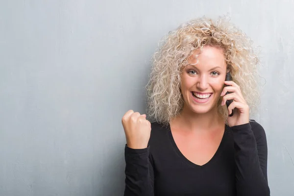 Young Blonde Woman Grunge Grey Background Talking Phone Screaming Proud — Stock Photo, Image