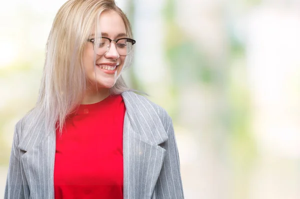 Young blonde business woman wearing fashion jacket over isolated background looking away to side with smile on face, natural expression. Laughing confident.