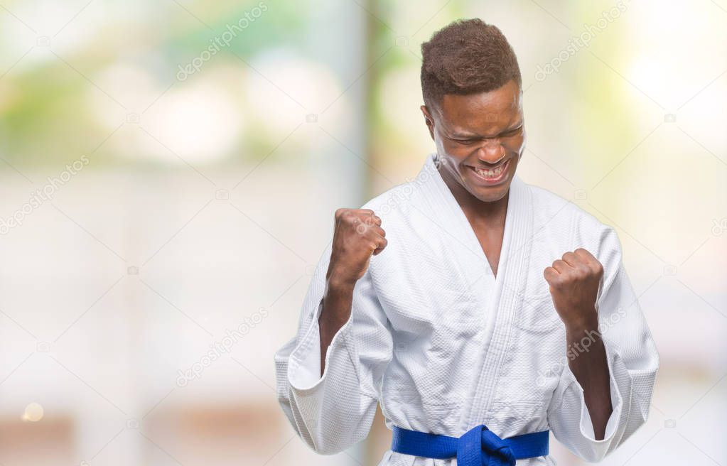 Young african american man over isolated background wearing kimono very happy and excited doing winner gesture with arms raised, smiling and screaming for success. Celebration concept.