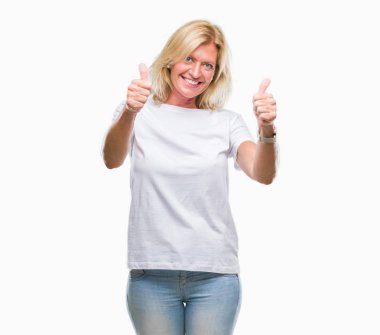 Orta yaş sarışın kadın el ile pozitif jest yapıyor onaylama izole arka plan üzerinde başparmak gülümseyen ve başarı için mutlu. Kamera, kazanan jest arıyorsunuz.