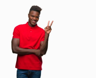 Afrikalı-Amerikalı genç mutlu yüz zafer işareti yaparken kameraya göz kırpıyor ile gülümseyen izole arka plan üzerinde. İki numaralı.
