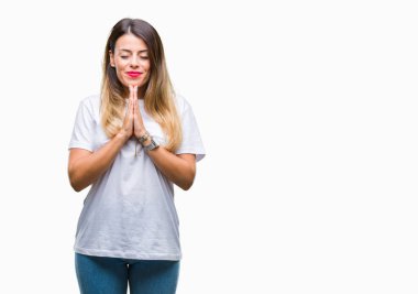 Casual beyaz t-shirt üzerine arka plan birlikte AF emin gülümseyen için soran ellerle dua izole genç güzel kadın.