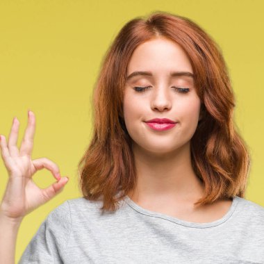 Genç güzel kadın izole arka plan üzerinde dinlenmek ve gülümseyen gözlerle parmak ile meditasyon jest yapıyor kapalı. Yoga kavramı.