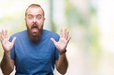 Genç beyaz hipster adam deli kutluyor arka plan izole ve başarı için kaldırdı kollarını açarak hayrete ve heyecanlı çığlık gözleri açık. Kazanan kavramı