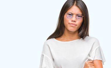 İzole arka plan şüpheci ve çapraz kolları olan yüzündeki gergin, onaylamayan ifade gözlüklü Genç Asyalı kadın. Negatif kişi.