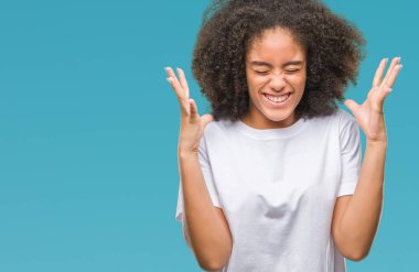 Genç afro Amerikalı kadın deli ve silah ile başarı için deli kutluyor izole arka plan üzerinde kaldırdı ve heyecanlı çığlık gözler kapalı. Kazanan kavramı