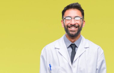Yüzünde mutlu ve güzel bir gülümseme ile izole arka plan üzerinde beyaz önlük giyiyor yetişkin Latin asıllı bilim adamı ya da doktor adam. Şanslı kişi.