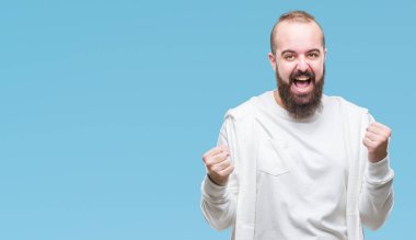 Genç beyaz hipster adam şaşırttı ve silah ile başarı için hayran izole arka plan kutlama üzerinde spor kıyafetlerle kaldırdı ve gözleri açık. Kazanan kavramı.