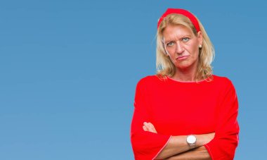 Orta yaş sarışın kadın izole arka plan şüpheci ve çapraz kolları olan yüzündeki gergin, onaylamayan ifade yüzünden. Negatif kişi.